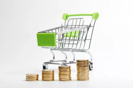 clanki/coins-pile-shopping-cart-white-background